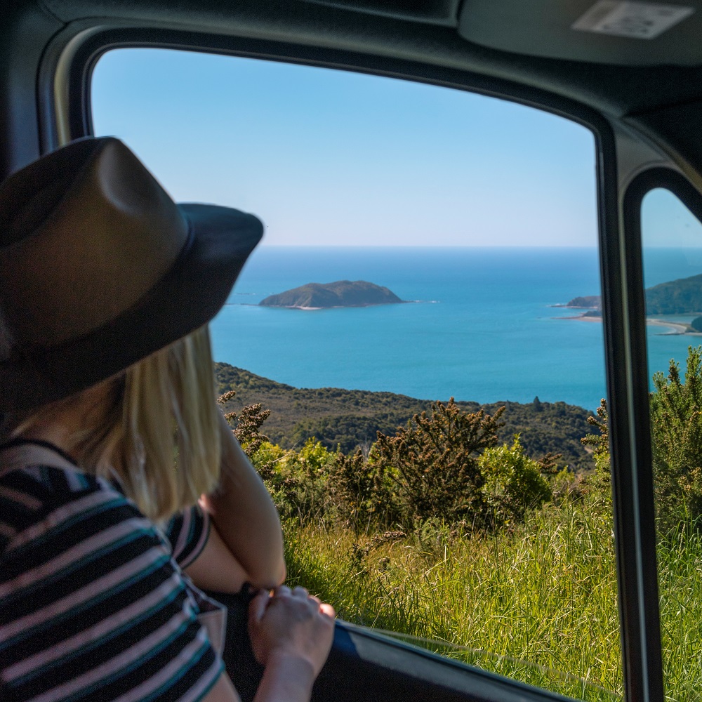 Woman stares out window of New Zealand campervan hrie